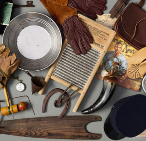 A collection of vintage items, reminiscent of tools used by early educators, including a washboard, gloves, hat, magazine, plates, tools, and a hunting horn arranged against a gray background.