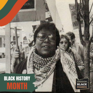 A Black woman in a keffiyeh scarf is leading a group of people with protest signs.