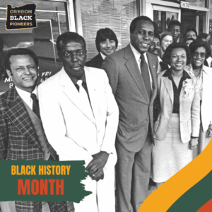 A diverse group of men and women stand together in front of a building, dressed in business attire. 