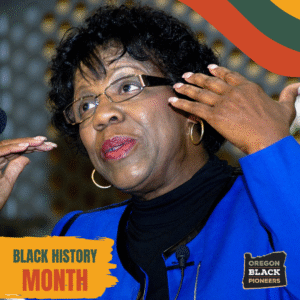 A Black woman speaks animatedly at an event, wearing glasses and a black top. Text reads "Black History Month" and "Oregon Black Pioneers.